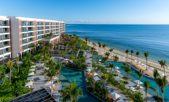 Fachada del hotel, piscinas al aire libre y playa cercana